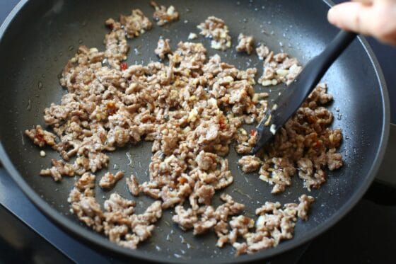 豆板醤を加えて炒め、辛味と香りを引き出す