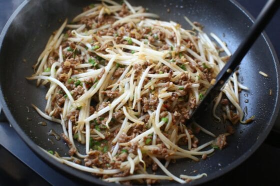 小ねぎを加えて仕上げ、ひき肉もやし炒めを完成させる