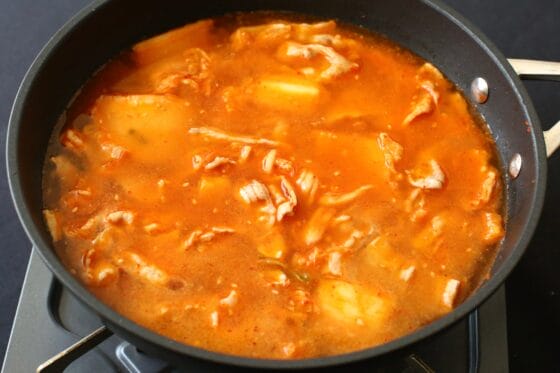 キムチと豚肉に和風だしと水を加えて煮立てる