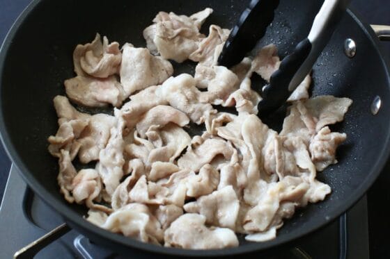 豚肉をフライパンで炒めて色が変わるまで加熱する