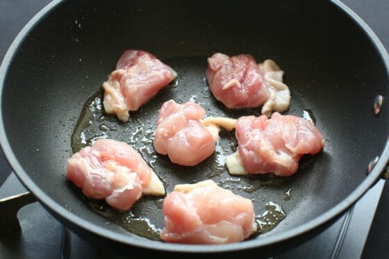 ごま油を熱したフライパンに鶏肉を並べる