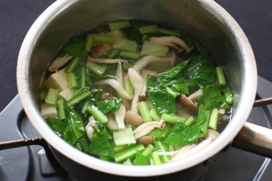 豆腐とかぶの葉を加えて煮る