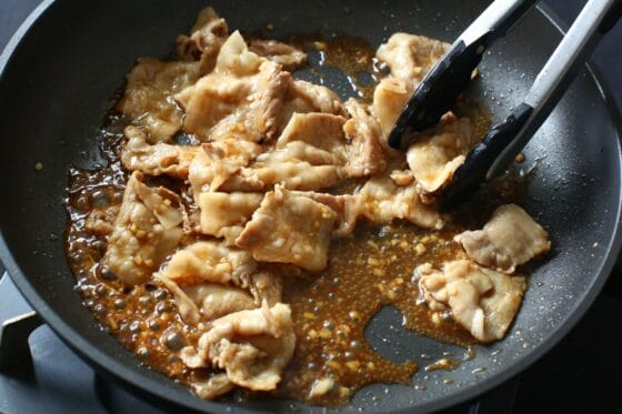 炒めた豚肉にタレを加えて絡める