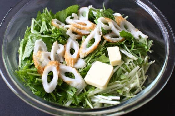 耐熱ボウルに水菜とちくわを入れ、上にバターをのせる