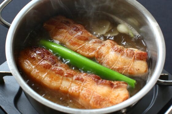 焼いた豚肉を鍋に入れて下ゆでを始める