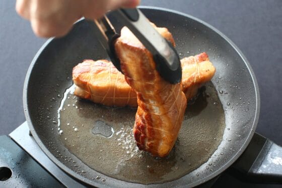 豚バラ肉をトングで立てて側面を焼く