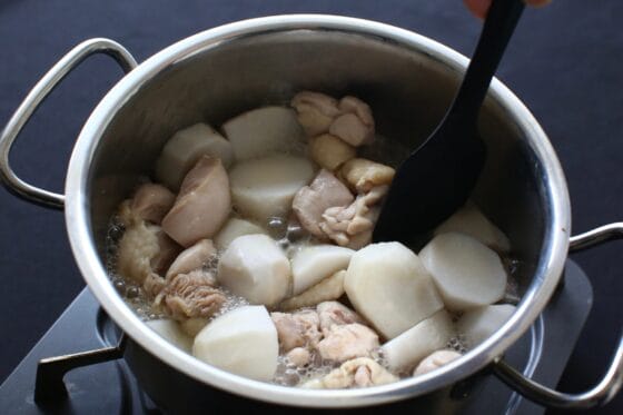 下茹でした里芋を鍋に加えて鶏肉と一緒に煮る