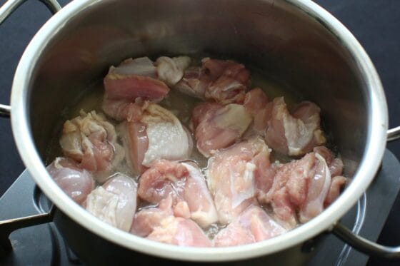 鶏もも肉を鍋で煮始めてうま味を出す