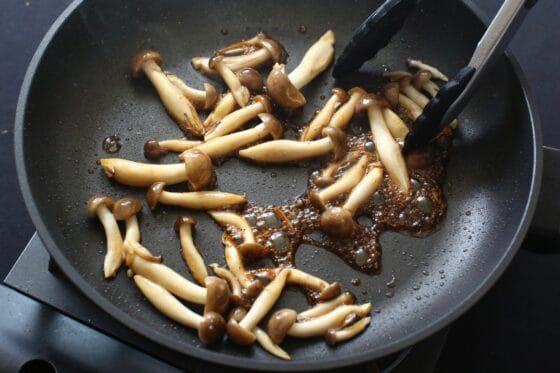 炒めたしめじを醤油とみりんで味付けする