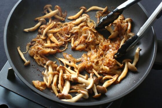 しめじと玉ねぎに醤油などの調味料を加えて炒める