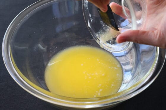 溶かしバターにグラニュー糖と三温糖を加えてヘラで均一に混ぜる