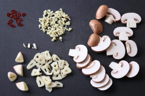マッシュルームとニンニクと生姜と鷹の爪を切る