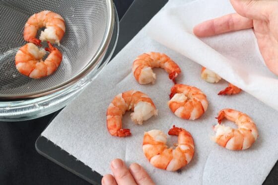 茹で上がったエビの水気を拭き取る