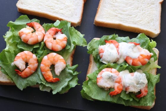 食パンにバターを塗り、レタスとエビを並べてソースをかける