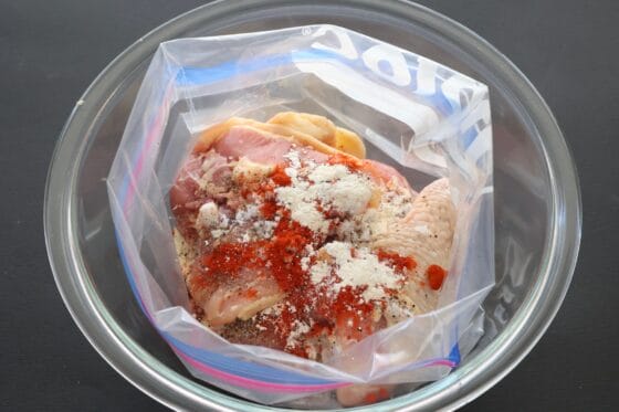 袋に入れた鶏肉に調味料を加える