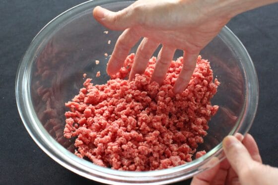 牛粗挽き肉に塩こしょうを混ぜる