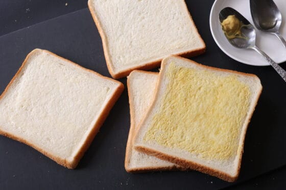 食パンにバターとマスタードとはちみつを塗る