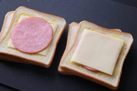 ハムとチーズを重ねてホットサンドを組み立てる