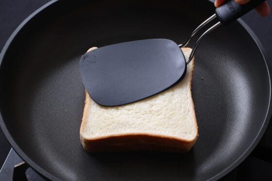 フライパンでホットサンドを押さえながら焼く
