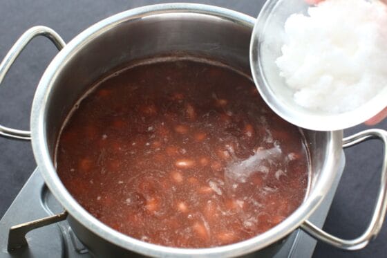 茹でた金時豆に砂糖の半量を加えて煮含める