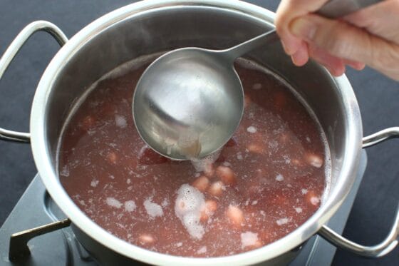 金時豆を茹でながらアクを丁寧に取り除く