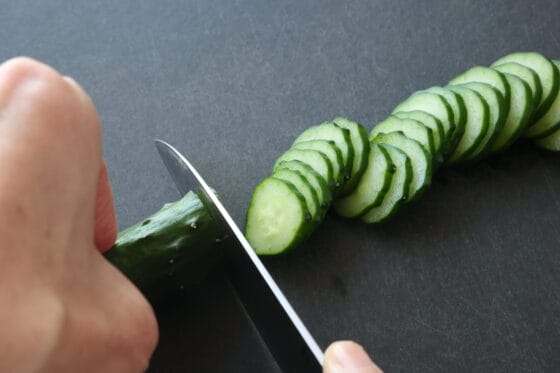 きゅうりを2〜3mm幅の輪切りにしてサンドイッチ用に準備する