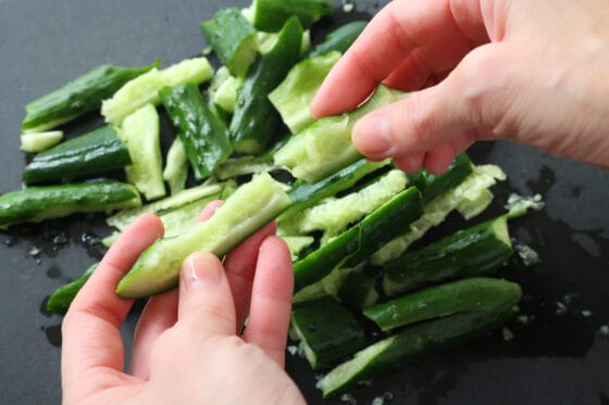 叩いたきゅうりを手で割って食べやすい大きさにする