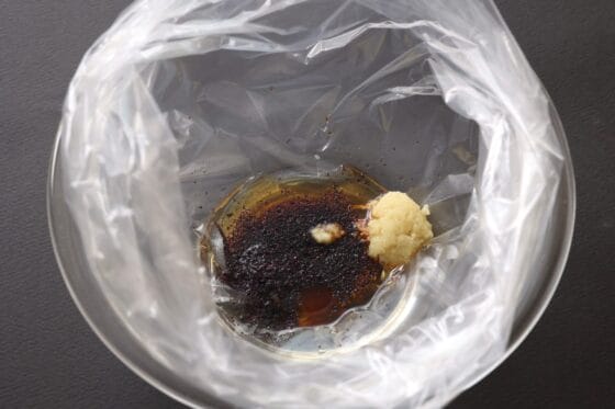 ポリ袋にゆかり・醤油・ごま油・おろし生姜・砂糖を入れる