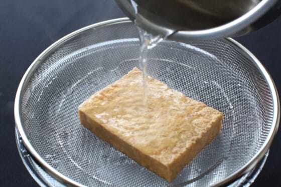 厚揚げに熱湯をかけて油抜きをする