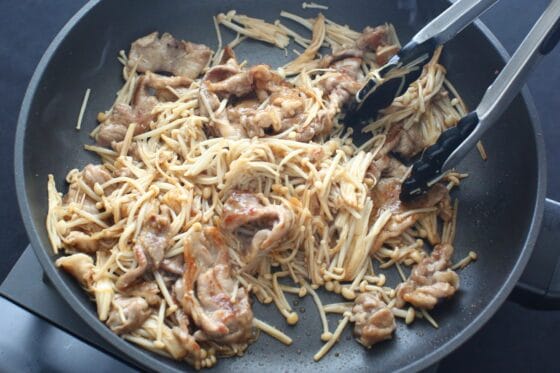 炒めた豚こまとえのきに調味料を加えて絡める
