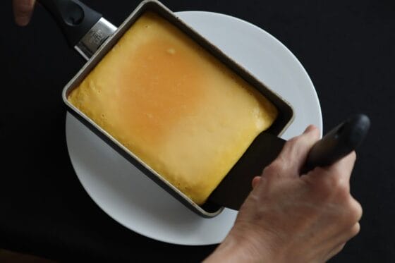 焼き上がった伊達巻の生地をフライ返しを使ってスライドさせて皿に移す