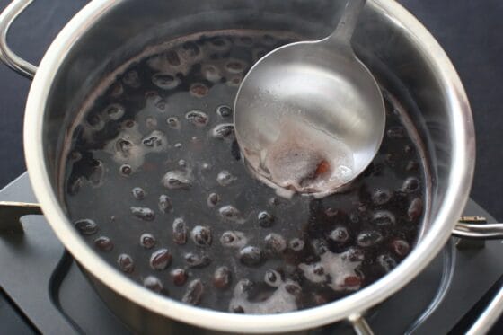 弱火で静かに黒豆を煮てアクを取る