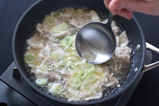 ネギを加えてアクを取り除く