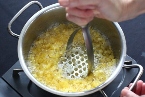 パイナップルをマッシャーでつぶしながら煮る