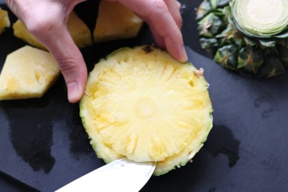 パイナップルの切り落とした上下の果肉を包丁で取り出す方法