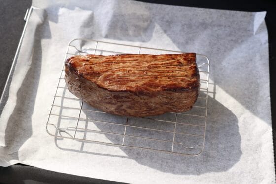 天板にクッキングシートを敷いて金網をおいて牛肉をのせる