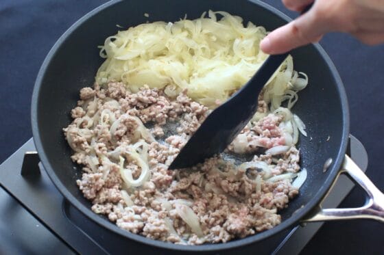 玉ねぎを端に寄せて空いたところにひき肉を加えて炒める