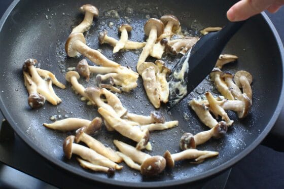 炒めたしめじに砂糖と酢を加えて軽く混ぜる