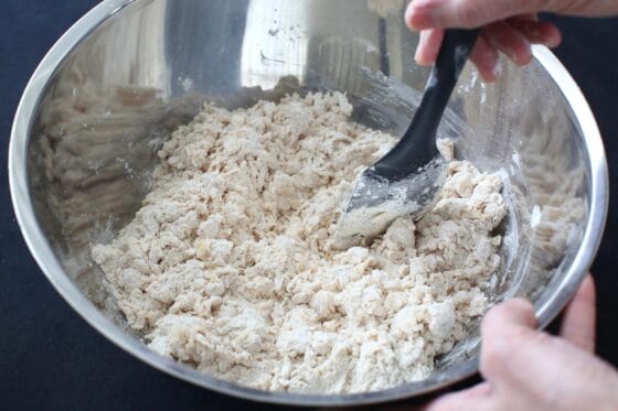 粉類にイーストを混ぜた牛乳と卵を加えてヘラで混ぜる