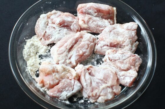 鶏もも肉に塩こしょうと薄力粉をまぶす