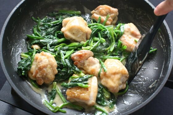 クリームソースをまとった鶏肉にほうれん草を加えて混ぜる