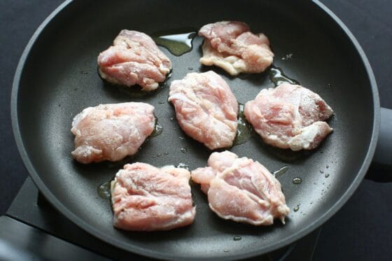 フライパンに鶏もも肉を並べる