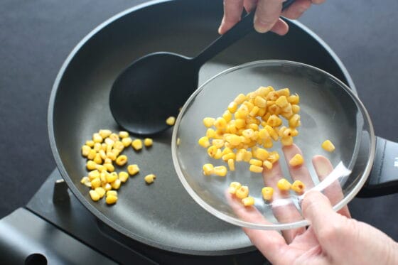 焼いたコーンをフライパンから取り出す