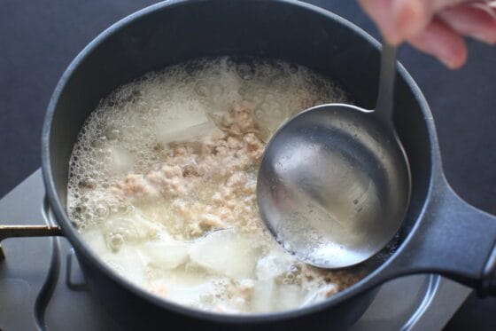 鶏ひき肉を加えてアクを取る