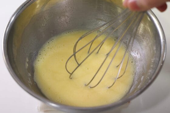 卵に牛乳とサラダ油を加えて泡立て器で混ぜる