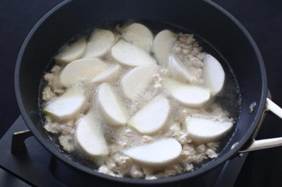 炒めたひき肉にかぶと和風顆粒だしと水を加える