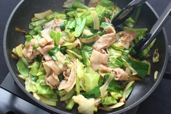 炒めたキャベツと豚肉にニラを加えて余熱で仕上げる