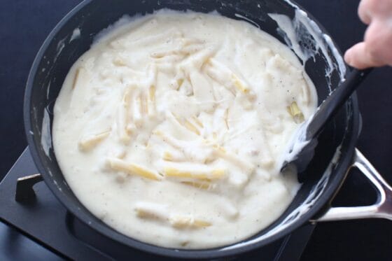 チーズソースにマカロニを混ぜる