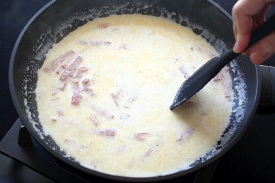 炒めたベーコンに生クリームと牛乳を加えて温める
