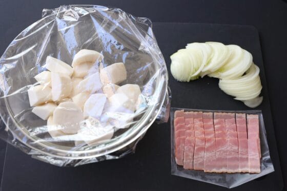 里芋を切って耐熱容器に入れてラップをかぶせる・玉ねぎとベーコンを切る